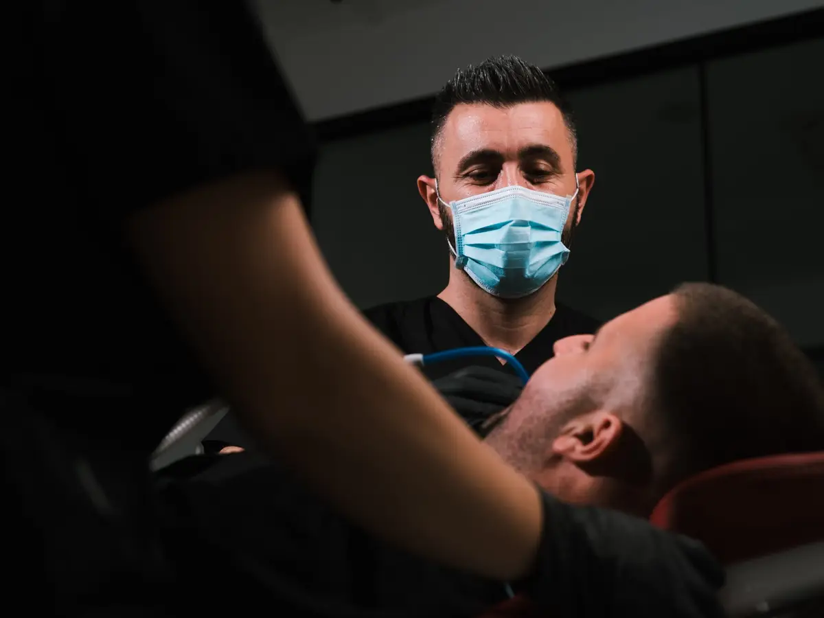 Dr Agron Shabani treating a patient with the help of a dental assistant