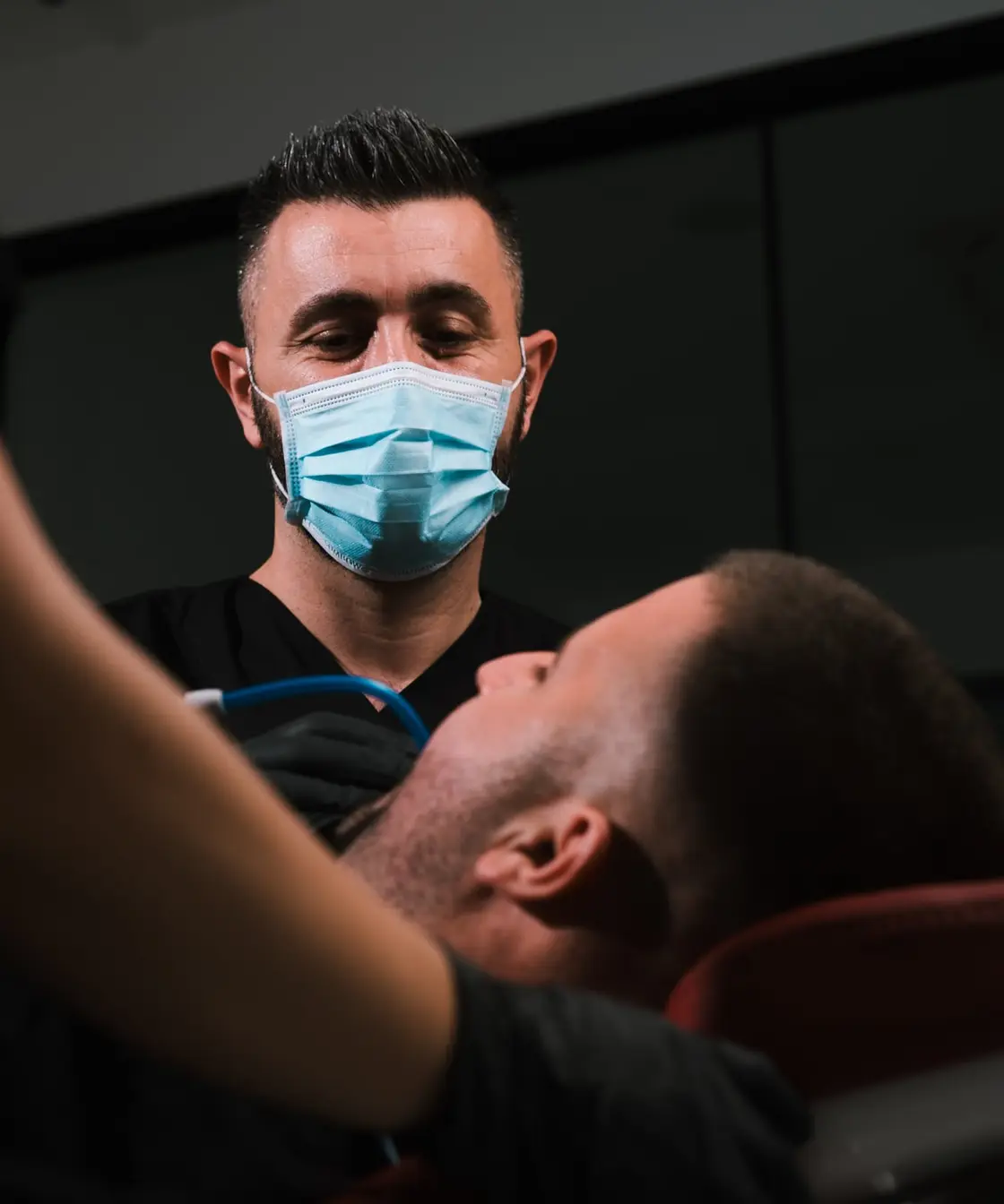 Dr Agron Shabani treating a patient with the help of a dental assistant
